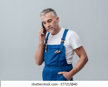 Confident repairman and plumber having a phone call with his smartphone - Powered by Shutterstock