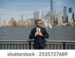 Confident rich business man executive standing in New York City. Business American success. American business dream. American businessmen in suits near Manhattan. Successful business in USA.