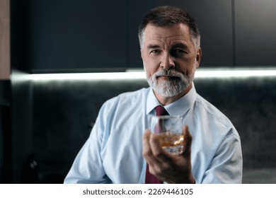 Confident rich mature wealthy businessman chilling relaxing drinking enjoying whiskey in the kitchen after work - Powered by Shutterstock