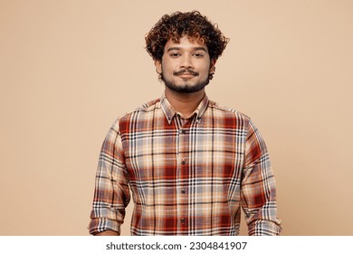 Confident satisfied cool student Indian man wearing checkered brown shirt casual clothes looking camera isolated on plain pastel light beige color background studio portrait. People lifestyle concept - Shutterstock ID 2304841907
