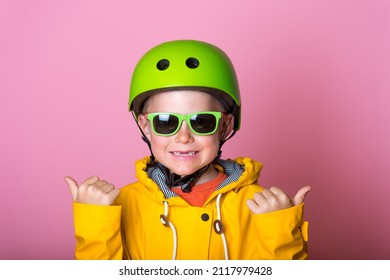 Confident School Boy In Full Sport Protect Equipment With Thumbs Up. Blond Kid Safety Helmet And Sunglasses. Child In Yellow Bright Clothes Isolated On Pink