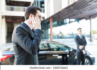 Confident Secret Service Agent Listening To Updates From Security Earpiece While Waiting By Car