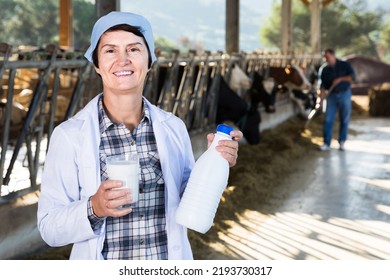 Confident Senior American Woman Veterinarian Approvingly Demonstrating Milk On Dairy Farm