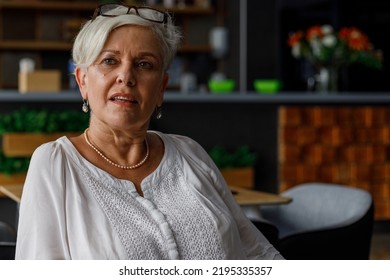 Confident Senior Female Executive With Short Hair Contemplating And Looking Away While Sitting In Office