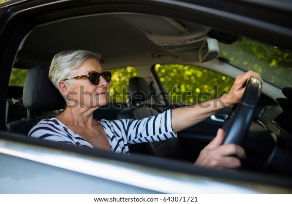 Confident senior woman driving\
car