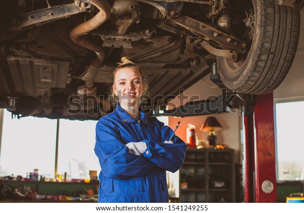 Confident smiling\
auto mechanic woman in\
overalls