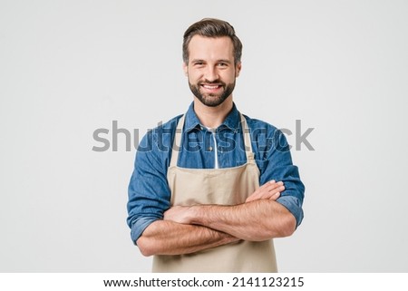 Confident smiling caucasian young man student bartender barista in apron with arms crossed looking at camera isolated in white background. Takeaway food