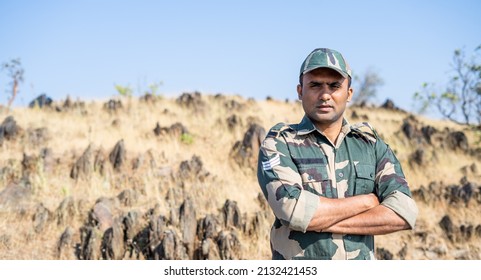 Confident smiling indian soldier in uniform standing with arms crossed by looking at camera with copy space - concept of successful, proud serviceman and occupation. - Shutterstock ID 2132421453