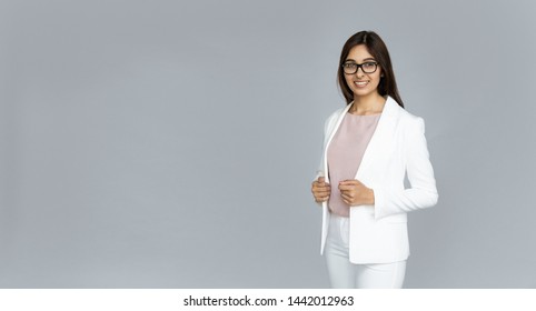 Confident smiling indian young elegant businesswoman wear suit glasses looking at camera isolated on grey studio background, happy hindu business lady in eyewear professional portrait, copy space