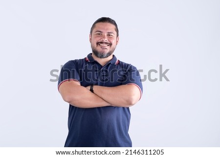 A confident smiling man of mixed race with arms crossed. Barrel chested guy in his Late thirties. Isolated against a white background.