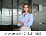 Confident smiling middle aged business woman attorney, 45 years old lady entrepreneur, mature female professional executive manager leader standing arms crossed in office looking at camera. Portrait.