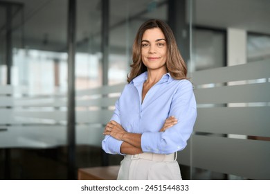Confident smiling middle aged business woman attorney, 45 years old lady entrepreneur, mature female professional executive manager leader standing arms crossed in office looking at camera. Portrait.