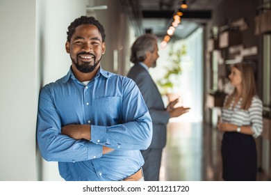 Confident smiling millennial african american businessman looking at camera in modern office, happy male professional company leader coach trainer posing alone, close up head shot business portrait