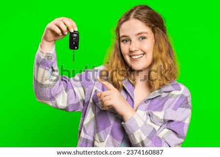 Confident smiling young caucasian woman buyer showing key of new car, auto business, purchase vehicle, success sale, renting, buying. Happy excited redhead girl isolated on green chroma key background