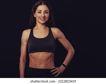 Confident Sportswoman In Grey Sportsbra And Shirt, Holding Hands On Waist, Fitness Trainer Standing In Power Pose, Workout In Gym Isolated On Black Background . Toned Vintage Color