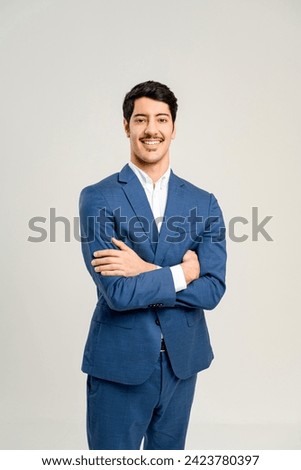 With a confident stance and a friendly smile, this young man in a tailored blue suit personifies the energetic and optimistic spirit of a rising star in the business world, isolated on white