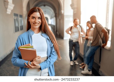 A confident student is depicted in a busy university hallway, holding books among a group of chatting peers, symbolizing the educational, social, and academic aspects of university life - Powered by Shutterstock