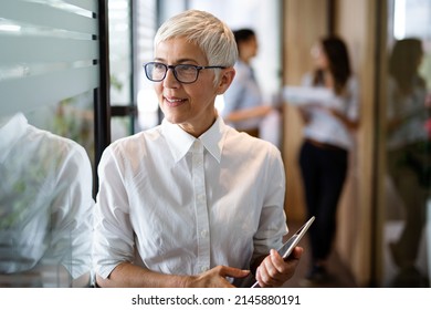Confident stylish european mature business woman standing at workplace. - Shutterstock ID 2145880191
