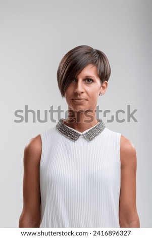 Confident and stylish, her direct gaze and sharp hairstyle reflect contemporary fashion sensibility [[stock_photo]] © 