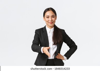 Confident Successful Businesswoman In Black Suit Extend Hand For Handshake, Greeting Business Partner With Pleased Determined Smile, Ready Sign Contract, White Background