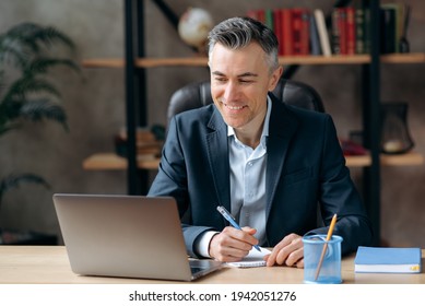 Confident Successful Handsome Caucasian Gray-haired Man, Manager Or Business Leader, Sitg In The Office, Communicating With Employees Via Video Conferencing, Conducts Broadcasting, Taking Notes,smile