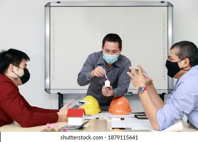 Confident Team Of Architect And Engineer Wearing Protective Masks Working Together In A Office. Architectural Concept. Social Distance Practice Prevent Coronavirus COVID-19.