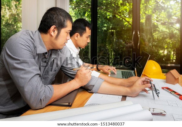Confident\
team of architect working together in a office.They discussing\
about new startup project on desk. Architect discuss with engineer\
about project in office, architectural\
concept