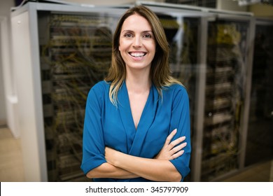 Confident technician smiling at camera at the data centre - Powered by Shutterstock