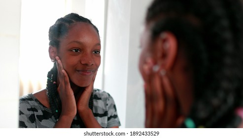 Confident teen adolescent black girl looking herself at mirror - Shutterstock ID 1892433529