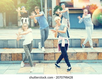 Confident Teen Boys And Girls Dancing Modern Choreography On City Street On Summer Day.