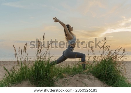 Confident Trainer Woman slim flexible body, practicing yoga exercise beautiful asana. Fitness on the background of sunset.  Meditation and harmony and balance of a person, mental health.
