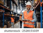 Confident warehouse manager smiling with tablet, organizing logistics and inventory efficiently. Expert in supply chain management, leading team with professionalism in retail industry