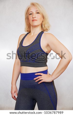 Similar – Close up front upper body portrait of one young athletic woman in sportswear in gym over dark background, looking at camera