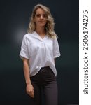 Confident woman in a crisp white blouse and dark pants poses gracefully, capturing modern elegance and style. Perfect for fashion, business casual, and lifestyle imagery.