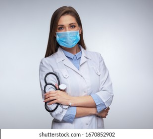 Confident Woman Doctor Wearing Medical Mask Standing With Crossed Arms. Isolated Female Portrait.