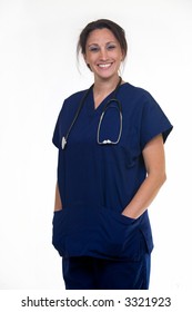 Confident Woman Healthcare Worker Wearing Dark Blue Scrubs With Stethoscope Around Shoulders With Hands In Pockets Smiling Standing On White