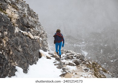 Confident Woman Hiker Reaching High Mountain Summit Walking on a Autumn Snowy Path in European Alps - Powered by Shutterstock