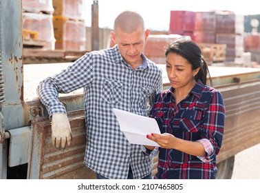 Confident Woman Manager Discussing Order List With Man Worker At Warehouse Of Building Materials