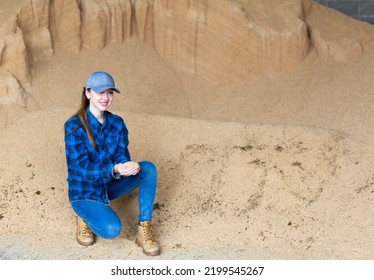 Confident Woman Owner Of Dairy Farm Checking Soybean Husk Animal Feed For Dairy Cattle In Storage Area