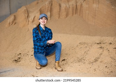 Confident Woman Owner Of Dairy Farm Checking Soybean Husk Animal Feed For Dairy Cattle In Storage Area