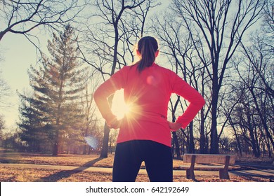 Confident woman preparing for a morning run in the park - Powered by Shutterstock