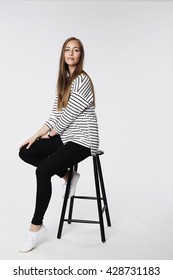 Confident Woman Sitting On Stool, Portrait