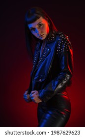 Confident Woman Wearing Black Leather Jacket Studio Portrait. Colored Gel Photography.