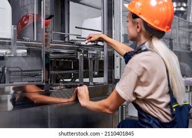 confident woman in work clothes at factory repairing robotic machine with wrench tool, caucasian young lady in protective workwear uniform mastered the male profession. feminism concept