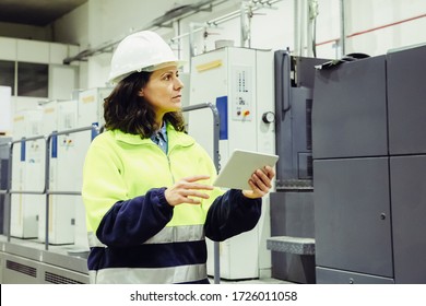 Confident Worker Using Tablet While Working At Factory. Focused Mature Woman Checking Equipment At Printing House. Print Manufacturing Concept