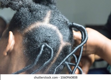 Confident young African American girl with long curly kinky hair in salon threading ethnic hairstyles for Afro hair growth, a dark brown skin girl with an African style, stylized hairstyles