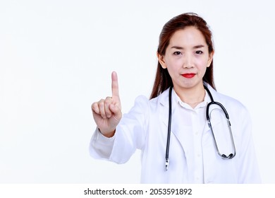 Confident Young Asian Female Medic In Uniform With Stethoscope Pointing Up With Index Finger While Giving Medical Advice Against White Background