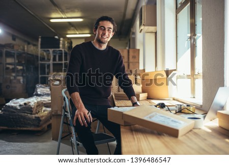 Confident young businessman working at online business store. Small business owner at his work desk.