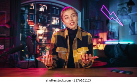 Confident Young Female Talking Into Microphone While Recording Radio Show from Her Loft Apartment. Happy Woman with Short Hair Talking on Camera and Recording Podcast Live on Social Media. - Powered by Shutterstock