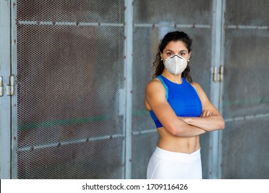 Confident young fit female athlete wearing face mask for protection against Covid-19. Sportswoman portrait outside. Workout success and healthy lifestyle concept. - Powered by Shutterstock